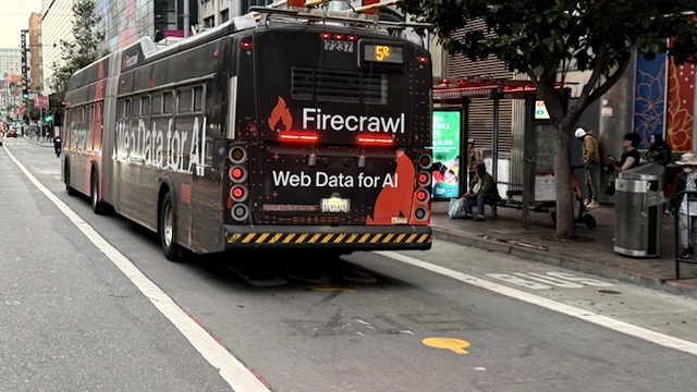 The back of a bus with an add for “Firecrawl” captioned “Web Data for AI”.